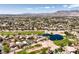 Community aerial view featuring a lush golf course, scenic pond, and mountain views in the distance at 5436 Red Sun Dr, Las Vegas, NV 89149