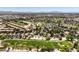 Expansive aerial view of a golf course community with red tile roofs, lush landscaping, and mountain backdrop at 5436 Red Sun Dr, Las Vegas, NV 89149