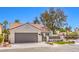 Charming single-story home with a two-car garage, tile roof, and manicured landscaping at 5436 Red Sun Dr, Las Vegas, NV 89149