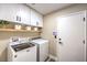 Laundry room with front load washer and dryer, upper cabinets and a wood shelf at 5436 Red Sun Dr, Las Vegas, NV 89149