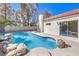 Beautiful backyard pool with rock features, privacy wall, and lush landscaping at 5436 Red Sun Dr, Las Vegas, NV 89149
