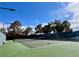 Well-maintained tennis court with pristine green surface, black net, and bright blue sky at 5436 Red Sun Dr, Las Vegas, NV 89149