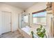 Bright bathroom with a soaking tub, shower, and large window, complemented by stylish decor at 5500 E Volterra Dr, Pahrump, NV 89061