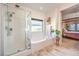 Bright bathroom featuring a soaking tub, glass-enclosed shower, and a view to the main bedroom at 5500 E Volterra Dr, Pahrump, NV 89061