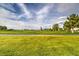 Expansive green golf course with lush fairways and mature trees under a partly cloudy blue sky at 5500 E Volterra Dr, Pahrump, NV 89061