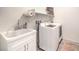 Bright laundry room features a utility sink with cabinet, washer, and dryer at 5500 E Volterra Dr, Pahrump, NV 89061