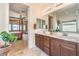 Well-lit main bathroom with double sinks, wood cabinets, and tile flooring at 5500 E Volterra Dr, Pahrump, NV 89061