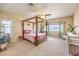 Spacious main bedroom with a four-poster bed, ceiling fan, and large windows providing natural light at 5500 E Volterra Dr, Pahrump, NV 89061