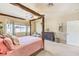 Bright main bedroom featuring a four-poster bed, neutral walls, and light-colored carpet at 5500 E Volterra Dr, Pahrump, NV 89061