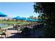 Picturesque outdoor seating area with blue umbrellas overlooking a serene pond and golf course at 5500 E Volterra Dr, Pahrump, NV 89061