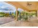 Covered outdoor patio with views of golf course, furnished with patio tables and chairs at 5500 E Volterra Dr, Pahrump, NV 89061