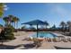Resort-style pool with lounge chairs, tables and lush palm trees, perfect for relaxation and enjoying the outdoors at 5500 E Volterra Dr, Pahrump, NV 89061