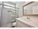 Updated bathroom featuring a glass shower with light gray tile and quartz countertops at 5575 Cresent Valley St, Las Vegas, NV 89148