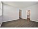 Spacious room with wood-look tile and light gray walls leading to a bathroom and closet at 5575 Cresent Valley St, Las Vegas, NV 89148