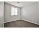 A gray-walled bedroom with wood-look tile flooring and modern baseboards, bathed in natural light at 5575 Cresent Valley St, Las Vegas, NV 89148