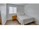 This bedroom features a comfortable bed, a nightstand, wood-look flooring, and a window at 5725 Smoke Ranch Rd # A, Las Vegas, NV 89108