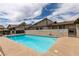 Outdoor pool with pristine blue water surrounded by a concrete patio and black metal fence near multi-story residential buildings at 5725 Smoke Ranch Rd # A, Las Vegas, NV 89108