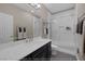 This renovated bathroom features shower with sliding glass doors, quartz countertops, and towel racks at 5858 Majestic Tide Ave, Las Vegas, NV 89131