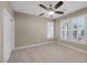 This bedroom offers neutral walls and carpeting, a ceiling fan, and shutters on the windows at 5858 Majestic Tide Ave, Las Vegas, NV 89131