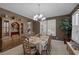 Traditional dining room featuring elegant chandelier, plantation shutters and curated china cabinet at 5858 Majestic Tide Ave, Las Vegas, NV 89131