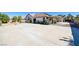 Expansive backyard showcasing a large paved area, covered patio, and lush landscaping at 5858 Majestic Tide Ave, Las Vegas, NV 89131