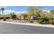 Well-maintained front yard with desert landscaping, mature trees, and a circular driveway at 5858 Majestic Tide Ave, Las Vegas, NV 89131