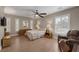 Relaxing bedroom with neutral tones features tile flooring, ceiling fan, and plantation shutters at 5858 Majestic Tide Ave, Las Vegas, NV 89131