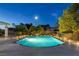Backyard pool with desert landscaping and ambient lighting offering a refreshing and serene outdoor space at 5858 Majestic Tide Ave, Las Vegas, NV 89131
