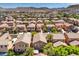 Aerial view of terracotta-roofed homes in a neighborhood with mountain views at 6046 Bassio Ave, Las Vegas, NV 89141