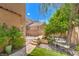 Private backyard features stone walkway, mature trees, and rock landscaping at 6046 Bassio Ave, Las Vegas, NV 89141