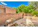 The backyard offers a stone picnic table, gravel landscaping, and a low brick wall at 6046 Bassio Ave, Las Vegas, NV 89141
