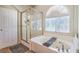 Bathroom showcasing a tub, a glass-door shower and natural light from the window at 6046 Bassio Ave, Las Vegas, NV 89141