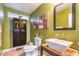 Modern powder room with pedestal sink, decorative mirror, and stylish green walls at 6046 Bassio Ave, Las Vegas, NV 89141