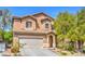 Inviting two-story home with an attached two-car garage and manicured landscaping at 6046 Bassio Ave, Las Vegas, NV 89141