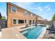 A sparkling swimming pool with a seating area is surrounded by a wall fence at 6047 Ancient Peaks Ave, Las Vegas, NV 89141