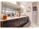 Dual sink vanity in a well-lit bathroom featuring dark cabinetry and modern fixtures at 6047 Ancient Peaks Ave, Las Vegas, NV 89141