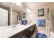 Bathroom with double sinks, large mirror, and bath tub with shower at 6047 Ancient Peaks Ave, Las Vegas, NV 89141
