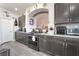 Modern kitchen with stainless steel appliances, gray cabinets, granite countertops, and a subway tile backsplash at 6047 Ancient Peaks Ave, Las Vegas, NV 89141