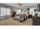 Spacious bedroom features neutral tones, a decorative ceiling fan, and plentiful natural light streaming through large windows at 6236 Desert Haven Rd, Las Vegas, NV 89130
