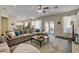 Open-concept living room featuring a comfortable sectional couch, ceiling fan, and seamless flow to the kitchen at 6236 Desert Haven Rd, Las Vegas, NV 89130
