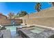 Stylish pool and spa combo surrounded by tropical landscaping and privacy walls at 6236 Desert Haven Rd, Las Vegas, NV 89130