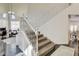 Elegant staircase featuring carpeted steps, a white railing, and natural light, enhancing the entryway's charm at 6236 Desert Haven Rd, Las Vegas, NV 89130