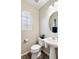 Comfortable half-bath with pedestal sink, round mirror, and decorative lighting at 6299 Oread Ave, Las Vegas, NV 89139