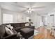 Spacious living room showcasing a sectional sofa, ceiling fan, and natural light from the bright windows at 6299 Oread Ave, Las Vegas, NV 89139