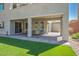 View of the covered patio, synthetic grass, and landscaped backyard at 6433 Farness St, Las Vegas, NV 89135