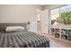 Sunlit bedroom with wood-look flooring, shelving, and large window, blending comfort with natural light at 6433 Farness St, Las Vegas, NV 89135