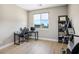 Bright bedroom with wood floors, black desk, and a large window with neighborhood views at 6433 Farness St, Las Vegas, NV 89135