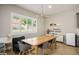 Dining area with a large wooden table with white shutters on the windows at 6433 Farness St, Las Vegas, NV 89135