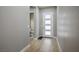 Bright entryway with a white front door, light wood-look flooring, and access to a nearby half-bathroom at 6433 Farness St, Las Vegas, NV 89135