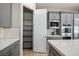 Walk-in pantry with open shelving next to the modern kitchen with quartz countertops at 6433 Farness St, Las Vegas, NV 89135